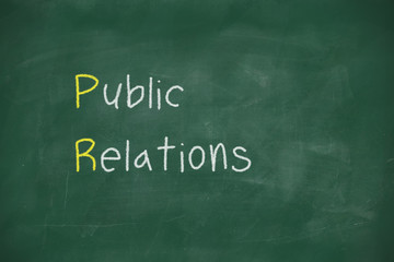 Obraz premium Public relations handwritten on blackboard