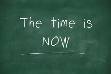 The time is now handwritten on blackboard