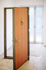 New wooden door in frame stands in hallway of unfinished house.