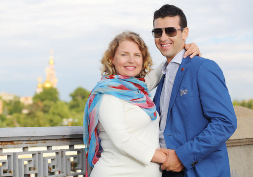 Stylish man in blue jacket and pregnant woman smile