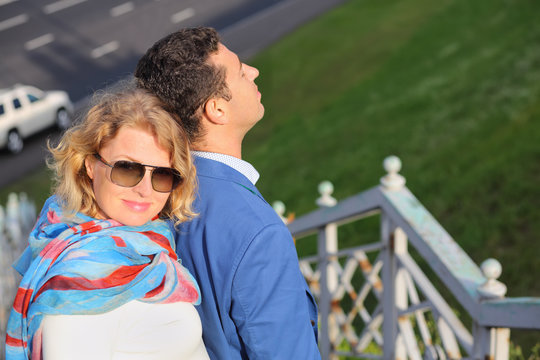 Stylish man in blue jacket and woman in sunglasses stands