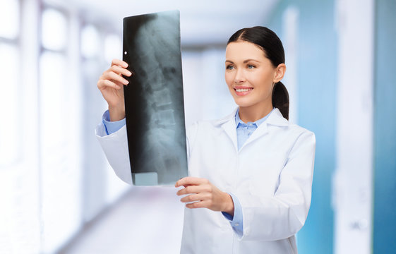 smiling female doctor looking at x-ray