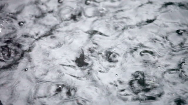 Rain drops rippling in a puddle