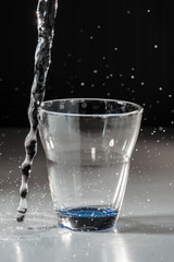 Versamento acqua nel bicchiere in  trasparenza