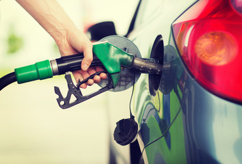 man pumping gasoline fuel in car at gas station - obrazy, fototapety, plakaty