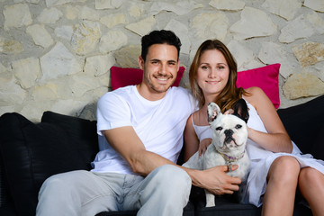 cheerful young woman with pet french bulldog in sofa outdoor