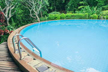 Swimming pool with stair in the green garden