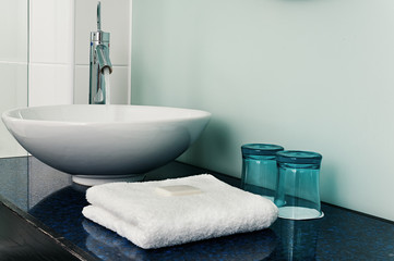 Obraz na płótnie Canvas Bathroom sink counter towels water glass blue