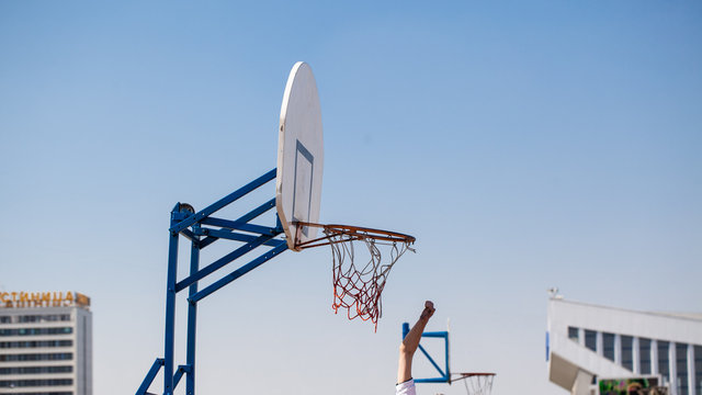 white basketball backboard and hoop on background of blue sky