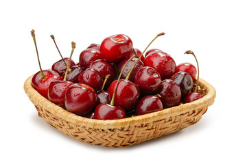 A heap of red fresh and natural cherries in a rattan basket