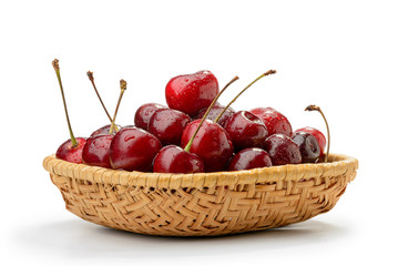 A heap of red fresh and natural cherries in a rattan basket