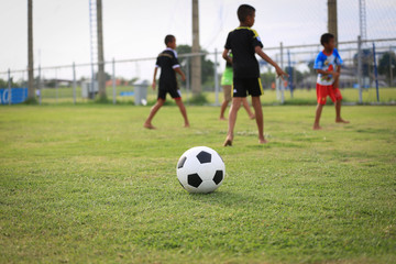 Obraz na płótnie Canvas Children playing football on the field