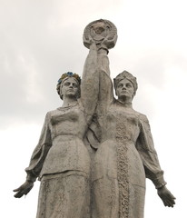 Fototapeta na wymiar OLSoviet monument. Russian and Ukrainian girls hold hands