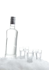 Bottle of vodka with glasses standing on ice on white background