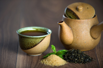 Cup of black  tea with mint leaves and brown sugar