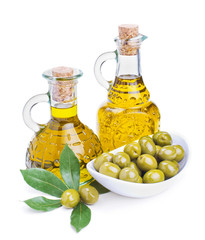 bottles of olive oil and green olives with leaves
