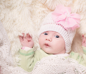 A cute little baby is looking into the camera