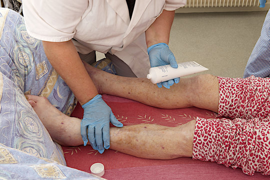 Nurse or care giver massaging foot and leg of a patient