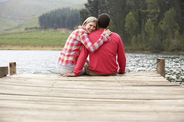 Fototapeta premium Romantic couple sitting on a jetty