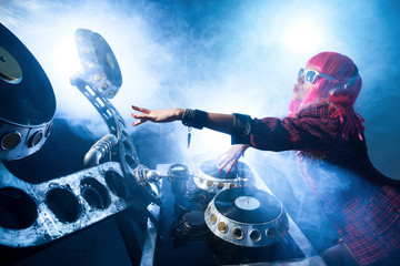 DJ girl in pink wig plays an unusual player in a nightclub - obrazy, fototapety, plakaty