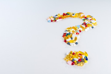Pills as question mark on white background with copy space