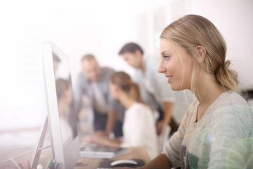 Young girl in office working on desktop computer