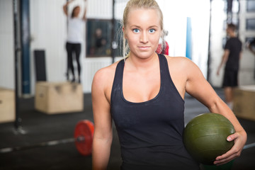 Fitness woman with slam ball at gym center