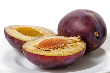 Half plum on a white plate