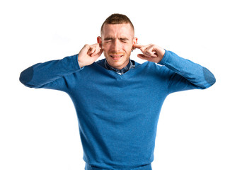 Redhead man covering his ears over white background