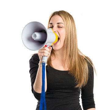 Pretty girl shouting with a megaphone over white background