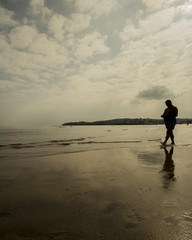 Naklejka premium Anciano paseando por la playa