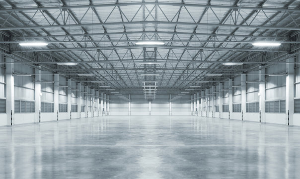 Concrete floor inside industrial building. Use as large factory, warehouse, storehouse, hangar or plant. Modern interior with metal wall and steel structure with empty space for industry background.