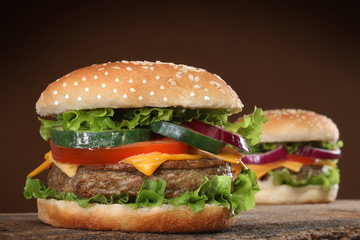 Two delicious hamburgers on wood background.