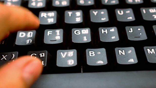 hands woman press on  keyboard with thai and english language