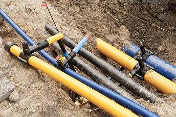 Gasrohre und Wasserrohre und Kabelschutzrohre in einer Baugrube