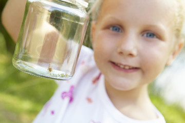 Little girl with cricket in a jar