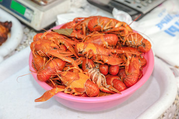 Plate with red boiled crawfish on a table close up