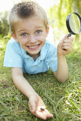 Young boy with beetle and magnifying glass