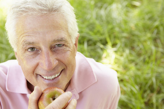 Senior Man Eating Apple Outdoors