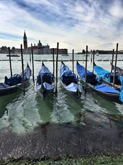 Fototapeta na wymiar Красивый вид на Гранд Канал в Венеции. Гондолы стоят на причале.