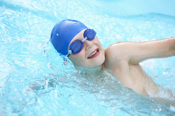 Fototapeta na wymiar Boy swimming in outdoor pool