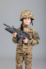 Young boy dressed like a soldier with rifle