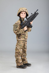 Young boy dressed like a soldier with rifle