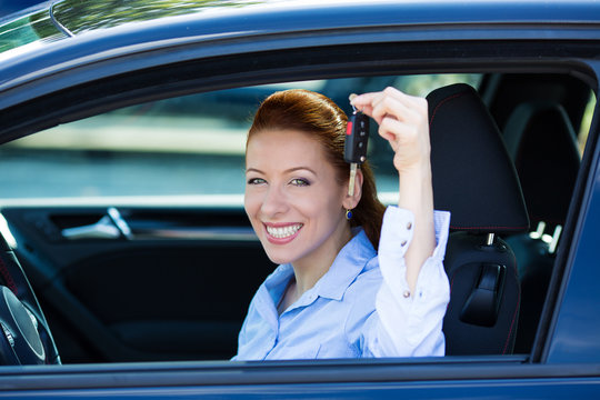 Happy excited driver woman showing keys from her new car