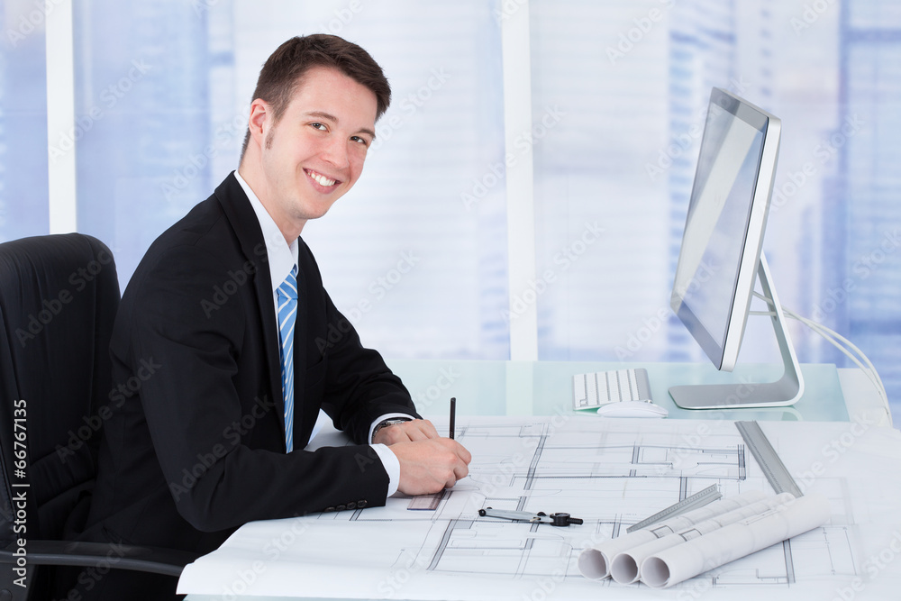 Poster architect working on blueprint at desk