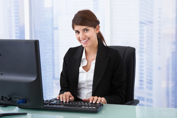 Businesswoman Using Computer At Office Desk