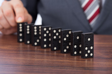 Businessman Playing Domino On Desk