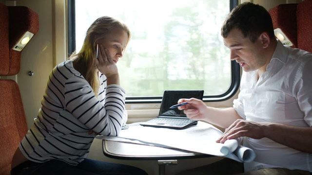 Man and woman discussing drawing during business trip in the
