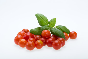 fresh cherry tomatoes with basil, on white background
