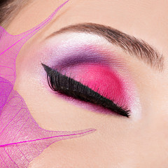 female eye with  beautiful fashion bright pink makeup